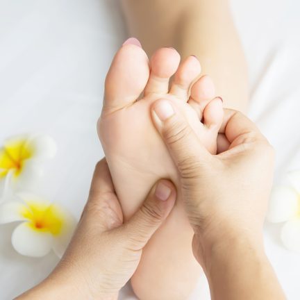Woman receiving foot massage service from masseuse close up at hand and foot - relax in foot massage therapy service concept